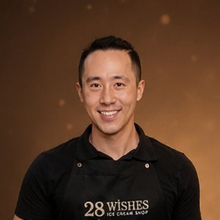 Jason, co-owner of 28 Wishes, smiling in a black 28 Wishes apron